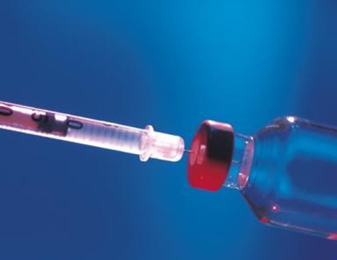 Syringe inserted into bottle