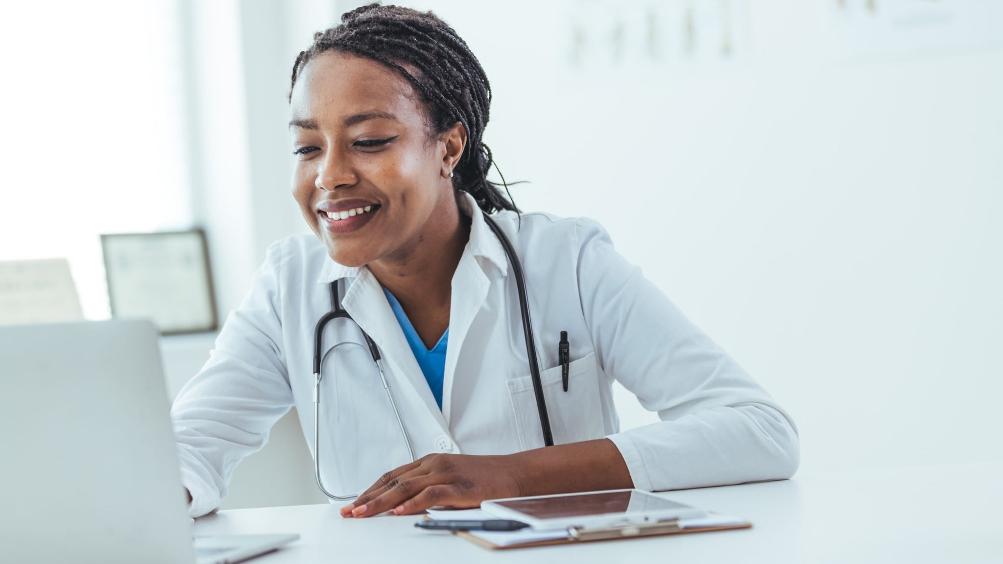 Doctor at laptop A smiling healthcare provider studies at a laptop.
