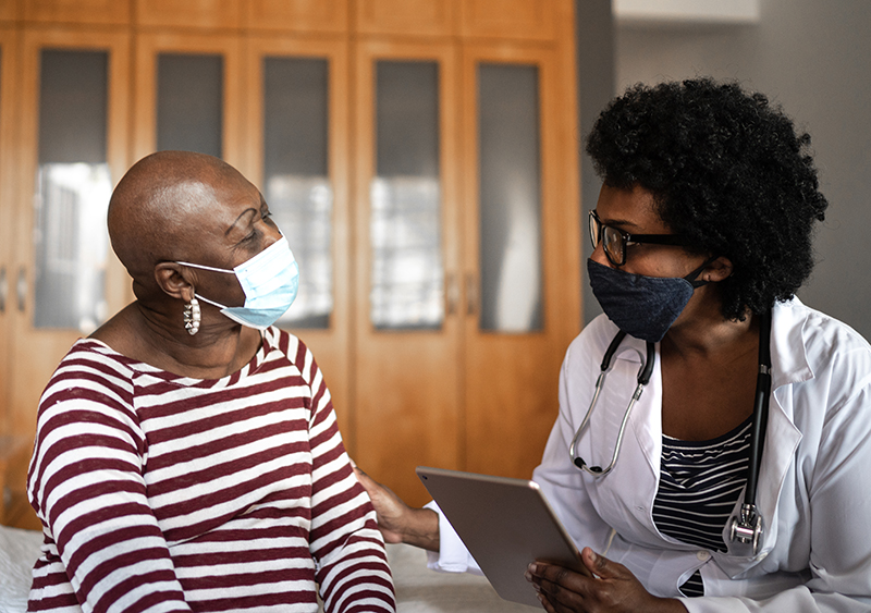 Health care provider talking to patient. Provider’s hand on patient’s arm Health care provider talking to patient. Provider’s hand on patient’s arm