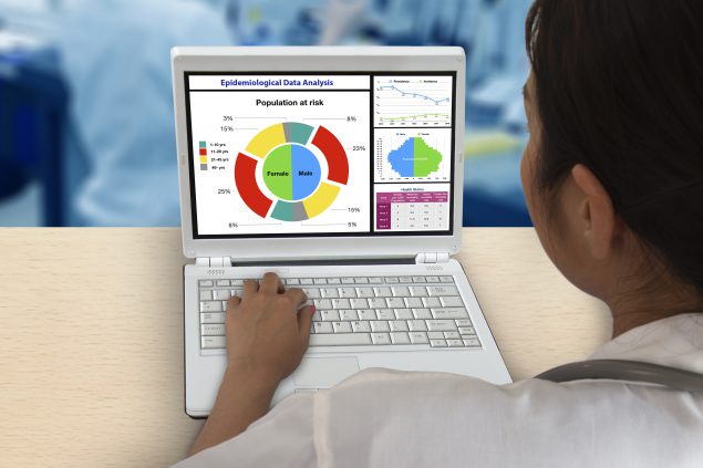 Looking over the shoulder of an epidemiologist at a laptop screen of chronic disease data.