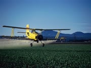 Photo of a plane dumping fertilizer on fields from the air