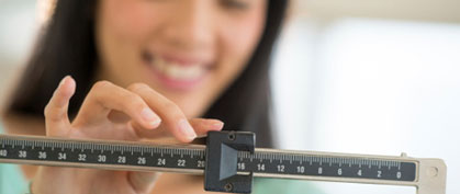 Assesing your weight Photo: Girl on a scale
