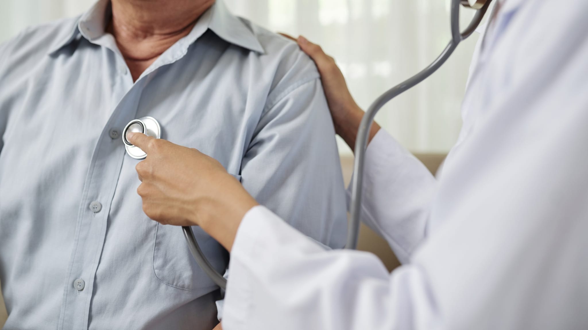 Doctor listening to a patient's heart with a stethoscope.