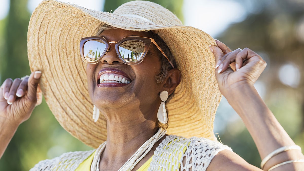 Woman wearing sunglasses and sun hat outside