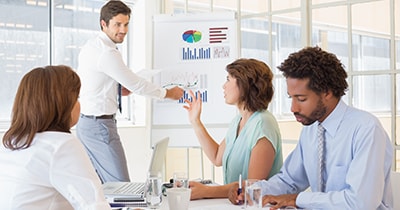 evaluation-400x210 Photo of people in a meeting studying charts