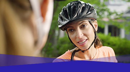 Women wearing bicycle helmet taking with another person