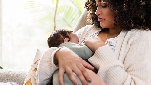 breastfeeding mother and baby New mom watches as baby breastfeeds