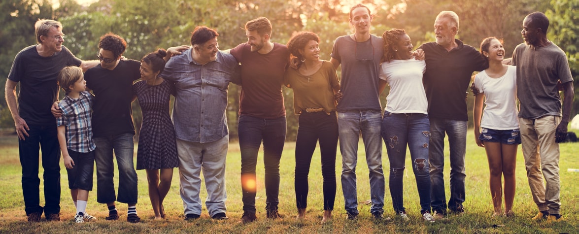 Image of a group of people of different ages and ethnicities standing together in a line with their arms around each other
