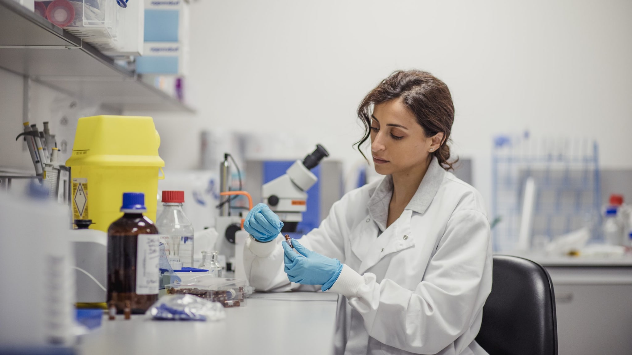 Lab worker looking into a microscope