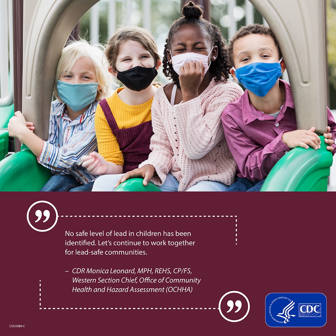 A group of children wearing masks sitting on slides at a playground.