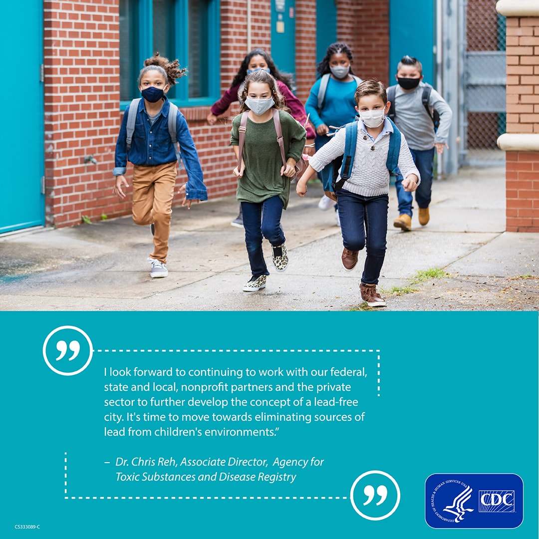 School children wearing mask and backpacks run down a path between two brick buildings with a quote on a blue banner below.