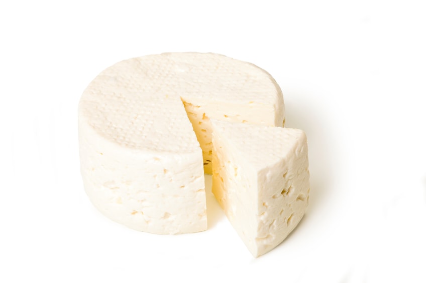 iStock_80203549-fresco.jpg Round block of soft white cheese with one slice cut.
