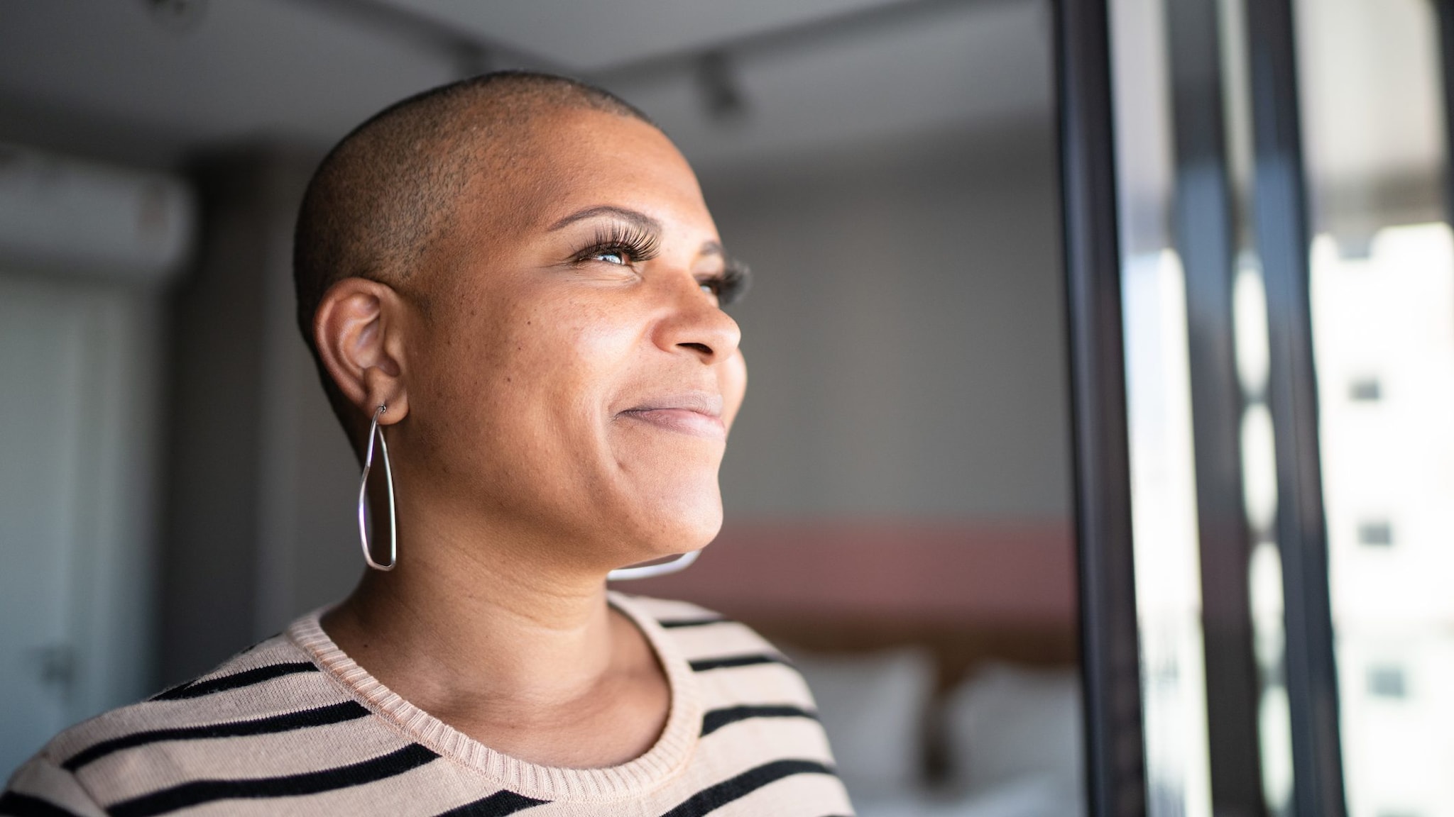Mature woman contemplating Woman contemplating at home looking out a window.