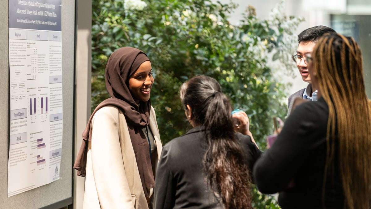 Student wearing a hijab discussing her project at CDC Student Showcase.