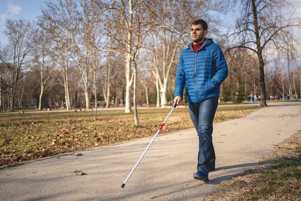 man with disability walking using a cane Man walks using a walking cane.