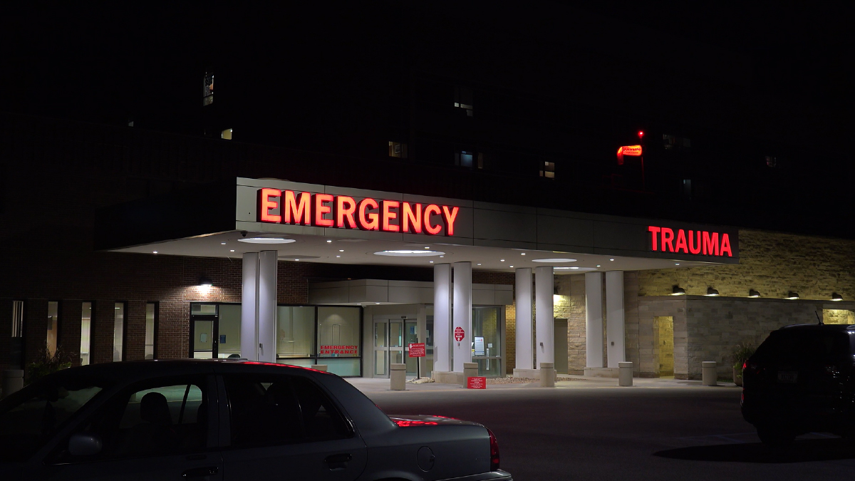 The figure is a photo of an entrance to an emergency department.