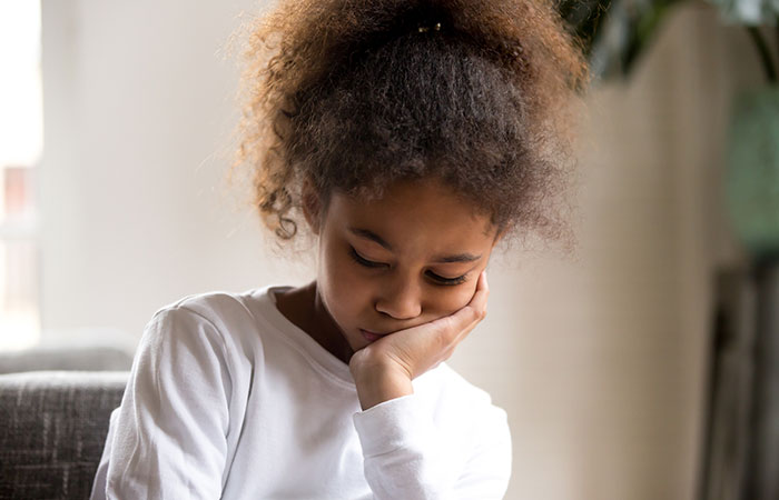 Upset girl feeling down sitting alone