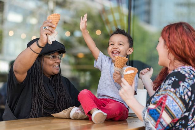 Kid raises hand while eating ice cream Kid raises hand while eating ice cream