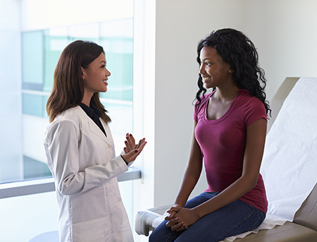 Young women speaking with her female doctor