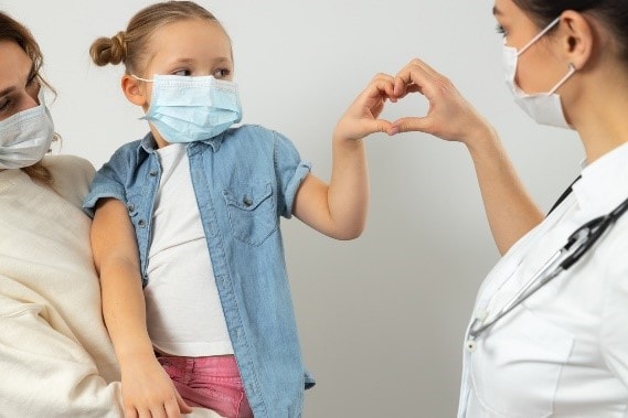 child-with-mask-at-doctor-visit A mother and daughter with protective masks visiting the doctor.