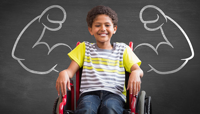 Duchenne Care Considerations A boy in a wheelchair in front of flexing arms drawn on a chalkboard.