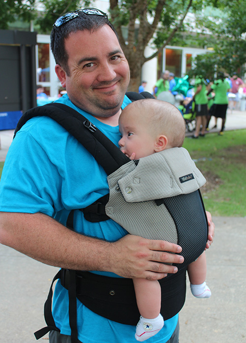 dad-baby Father holding his baby in a chest baby carrier