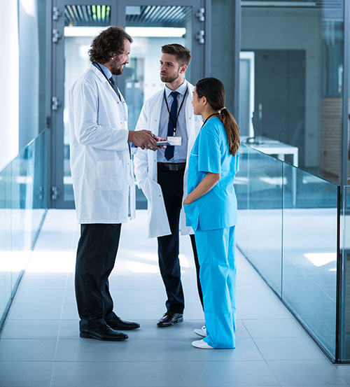 Group of doctors talking in a hallway Group of doctors talking in a hallway