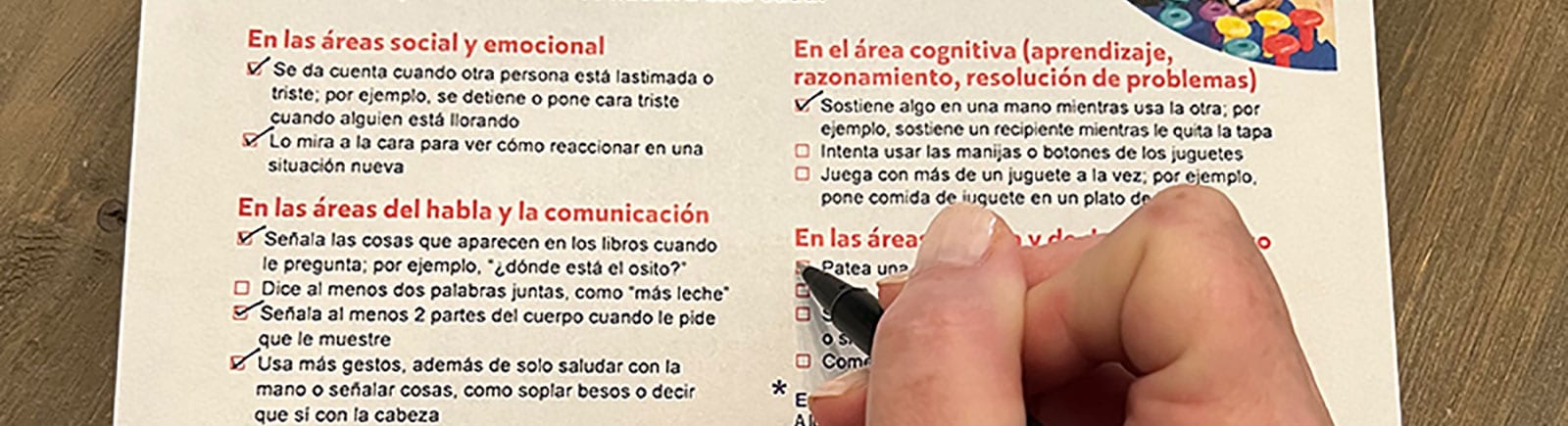 Una mujer completa una lista de un ni?o de dos a?os de edad.