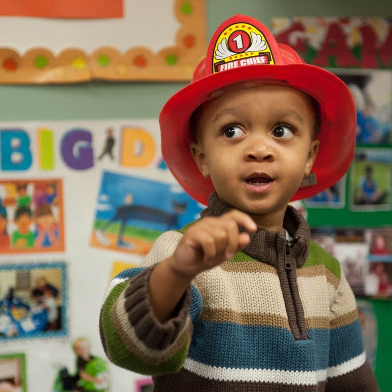 Ni?o con un casco de bombero.