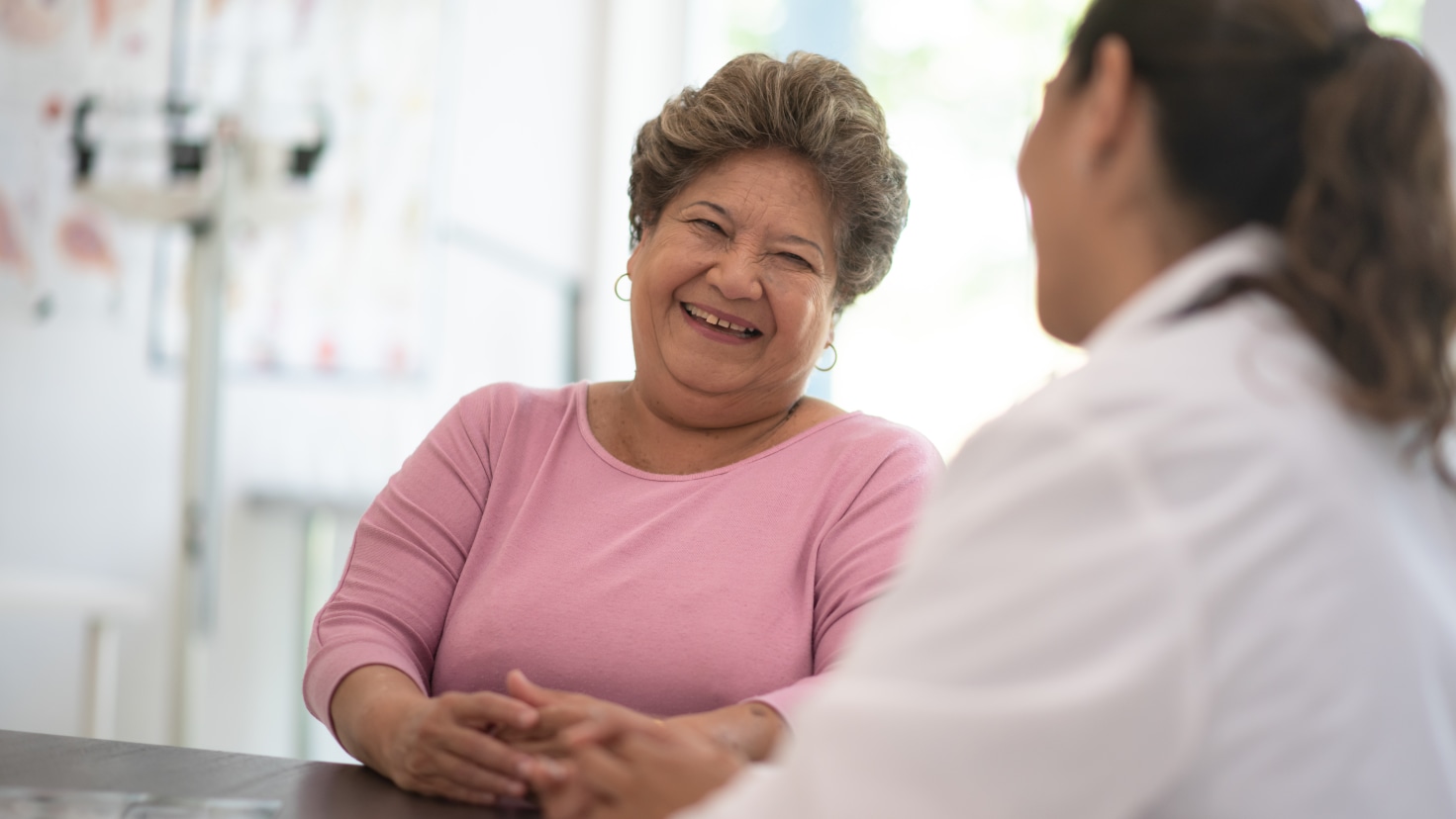 About Us DCPC Middle-aged female patient talking with doctor.