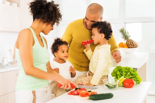 African American family prepares vegetables in kitchen.