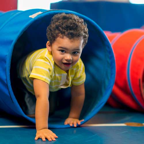 A boy crawling out of a tunnel