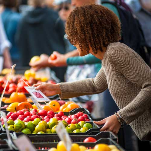 A shopper looking a fresh produce at a farmer's market