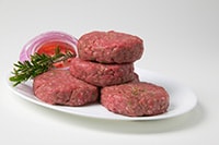 Plate of raw hamburger patties.
