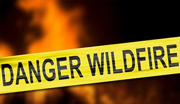 Yellow caution tape that reads "DANGER WILDFIRE"
