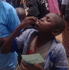 school-boy-cameroon A young boy takes a dose of the oral cholera vaccine distributed in his village in northern Cameroon.