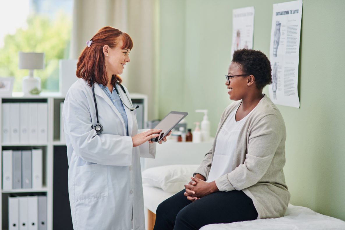 Shot of a doctor using a digital tablet during a consultation with a woman