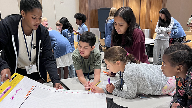 2024 Data Detectives Atlanta - 1 Students looking at a chart that the instructor is showing.