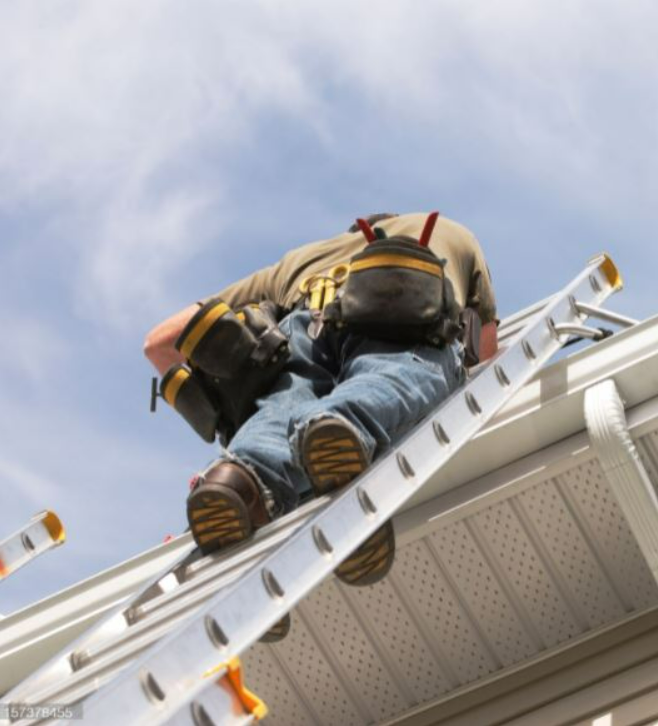 DD Image March back of man on a ladder near the roof of a house