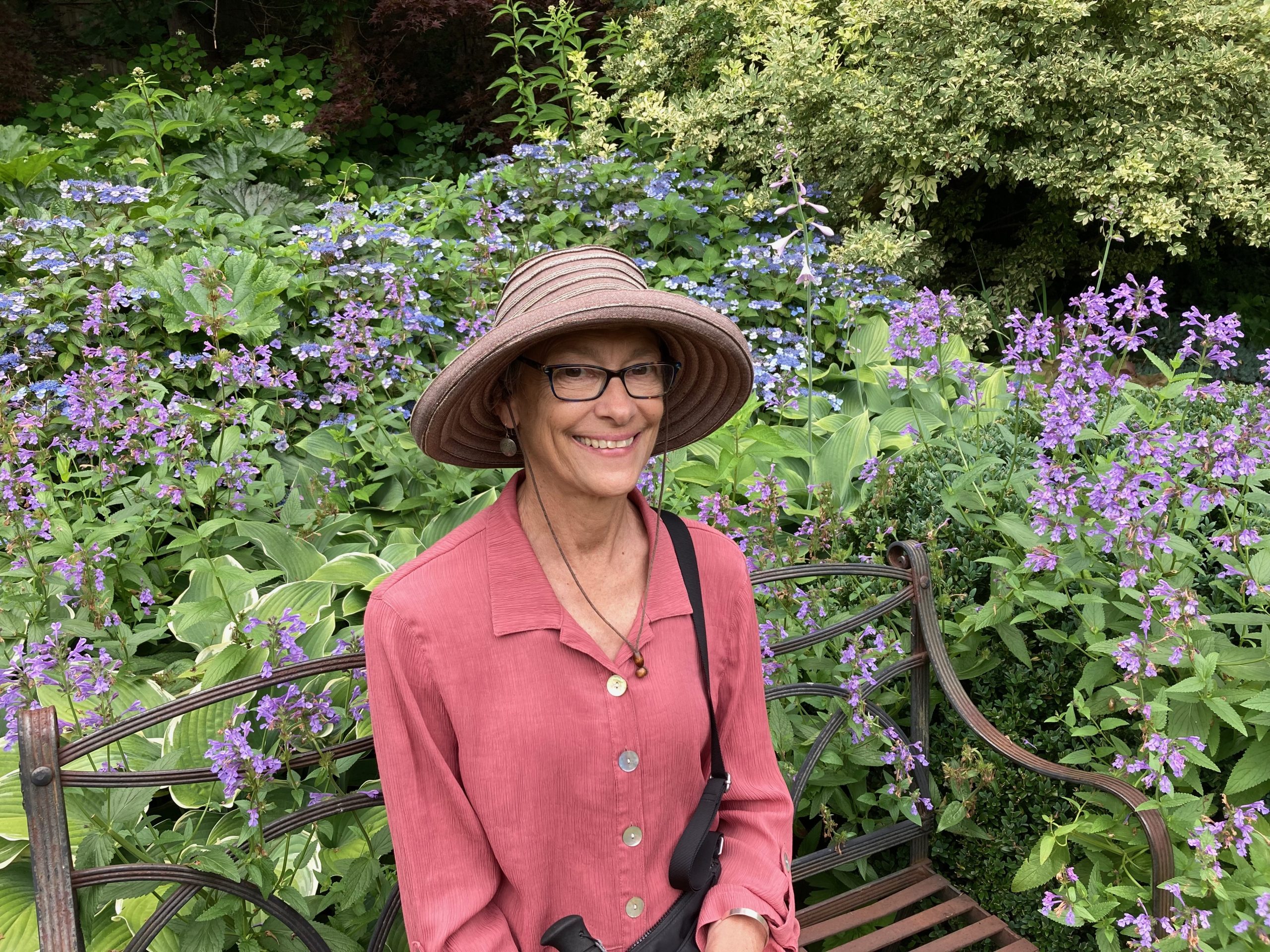 Photo of Jessica Kogel Photo of Jessica Kogel standing in front of purple wild flowers. She is smiling and wearing a pink short and large hat.