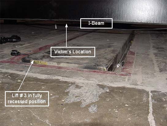 lift #3 where victim was lying when scissors lift was activated. Victim was beneath Black I-beam. Lavatory drain found on floor to left of lift.