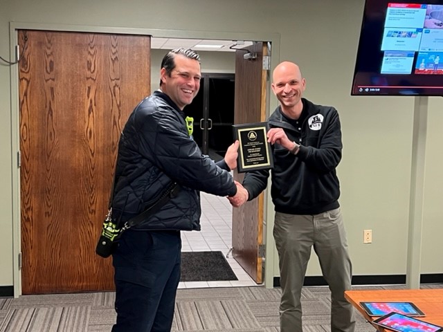 LSFD2 A person holding a plaque and shaking another person's hand