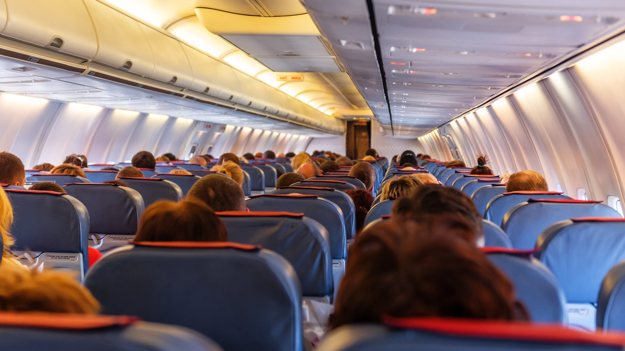 887322914 Interior of a commercial jet shown from the rear of the cabin.