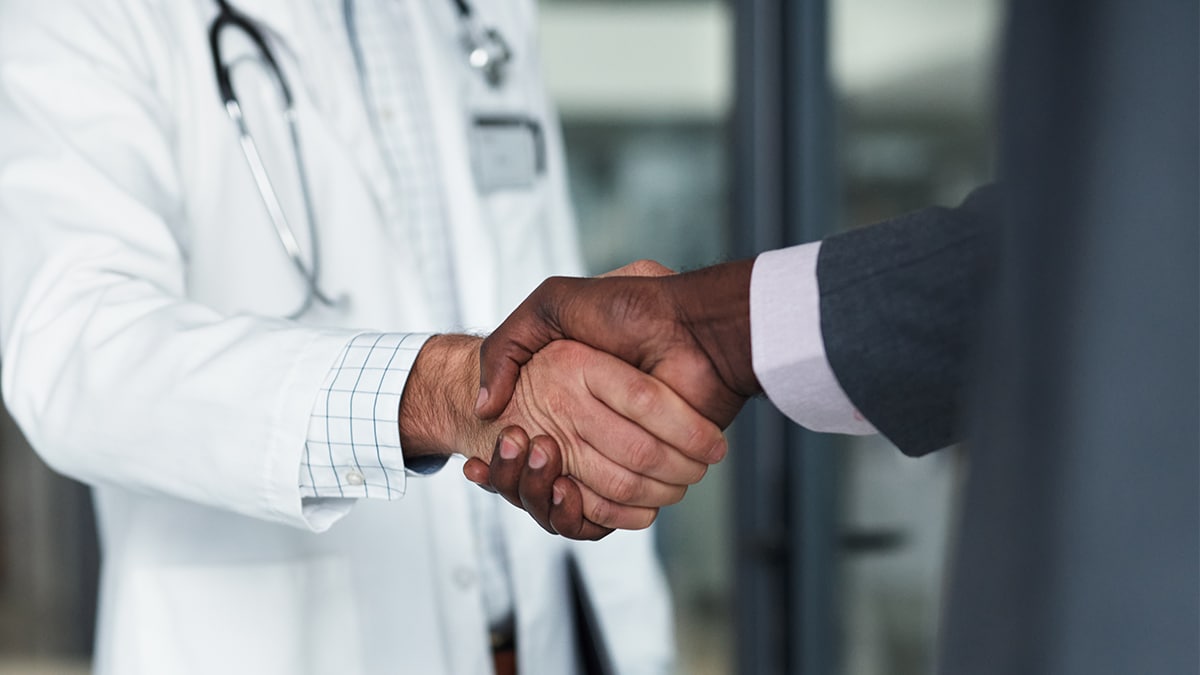Advocating for Guide Use 4 Closeup of a handshake between a physician and executive.
