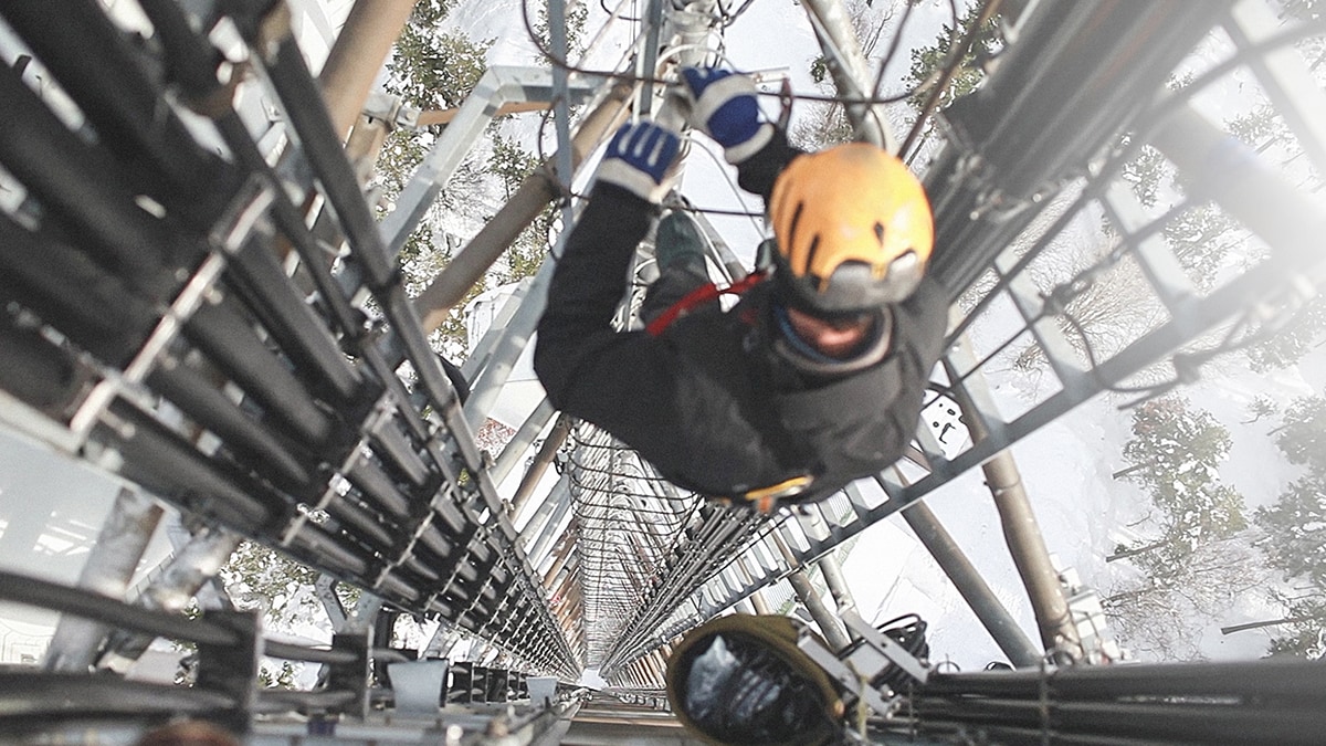 Telecommunication worker repairing communication tower.