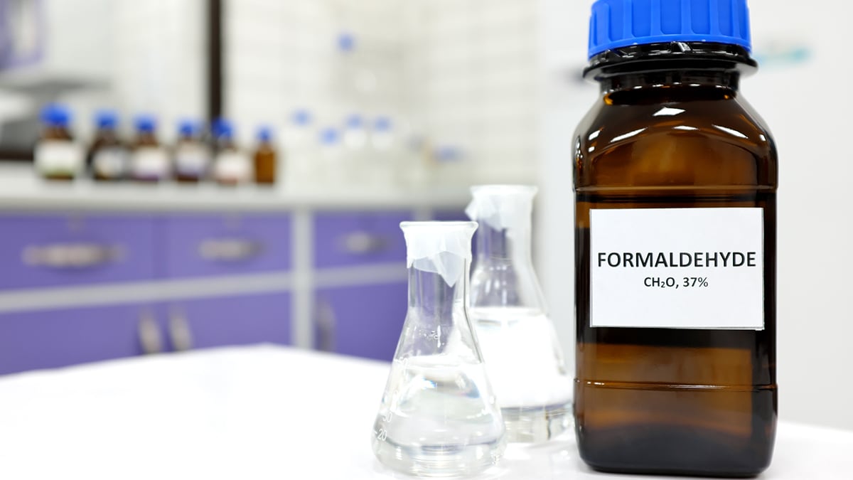 — title missing — A bottle of formaldehyde shown in the foreground of a laboratory setting.