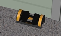 A boot cleaning brush on the ground near mobile equipment and at the entrance of the building/shed.