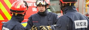 Three rescue workers talking by rescue vehicle Rescue workers