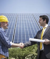 solarpanelshake Image of workers shaking hands in front of a building certified as green