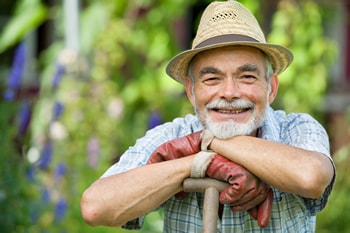 farmer A farmer leans on a tool and smiles.